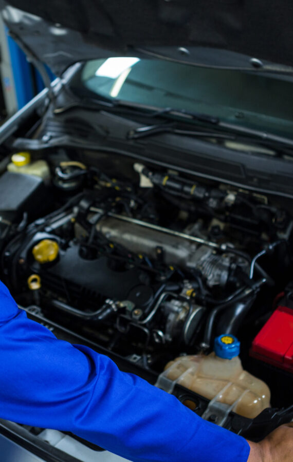 Portrait of happy mechanic servicing car at repair garage