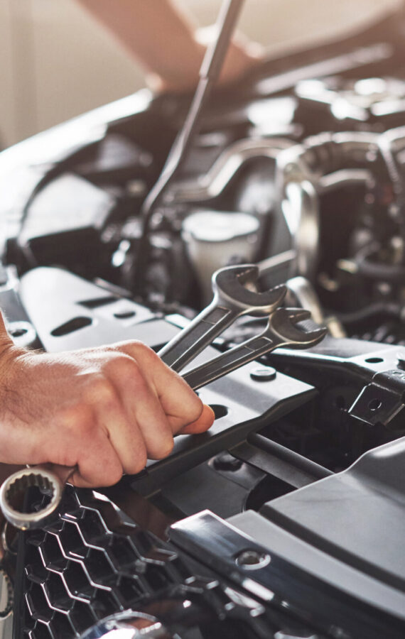 Picture showing muscular car service worker repairing vehicle.
